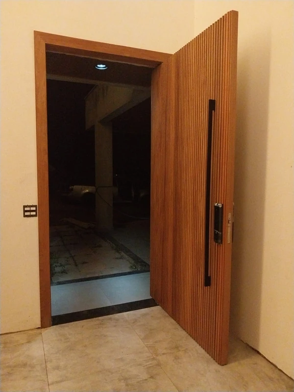 Porta ripada de madeira aberta em uma moldura interna com puxador vertical.