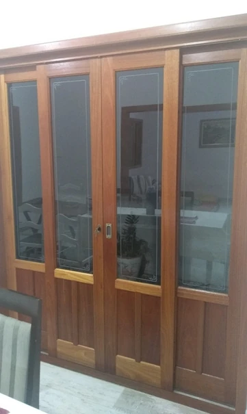Porta de madeira com quatro folhas envidraçadas e painéis sólidos na parte inferior.