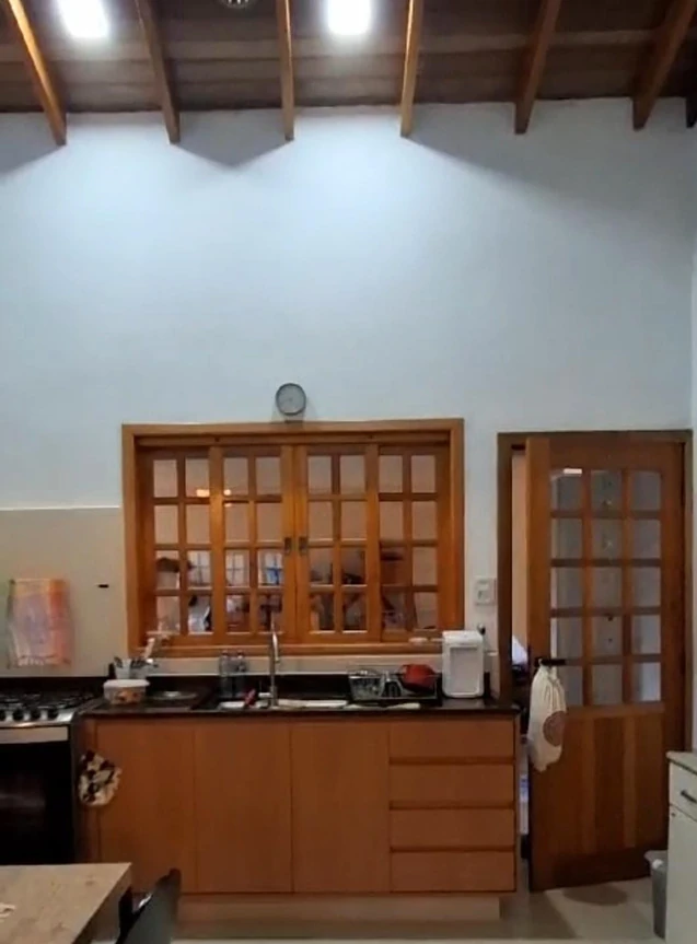 Janela e porta de madeira com quadrículas de vidro em uma cozinha com armários.
